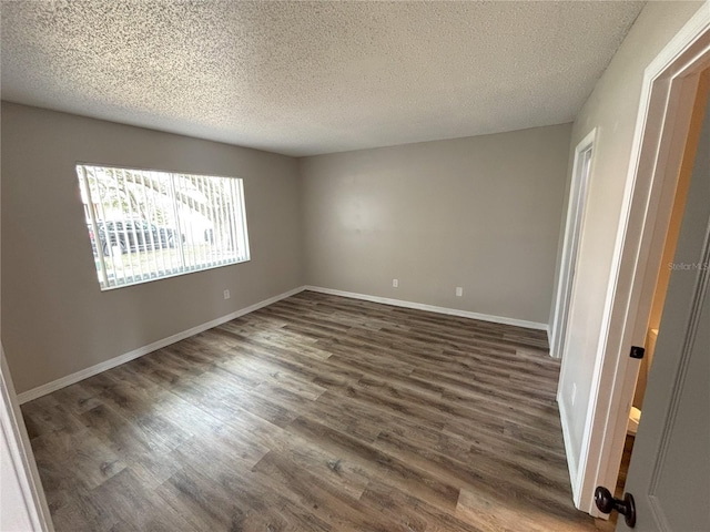 unfurnished bedroom featuring a textured ceiling, baseboards, and dark wood-style flooring