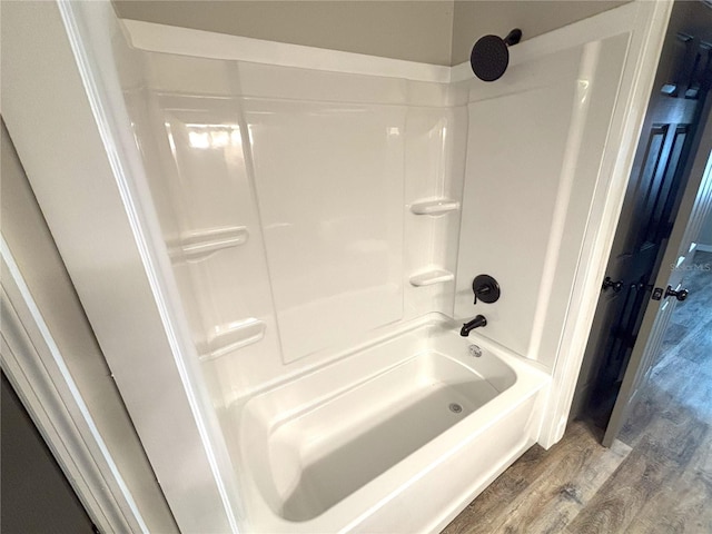 full bathroom with washtub / shower combination and wood finished floors