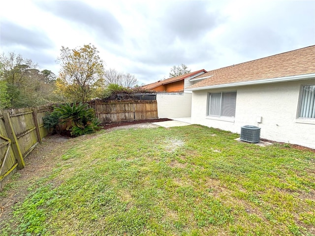 view of yard with a fenced backyard and central AC