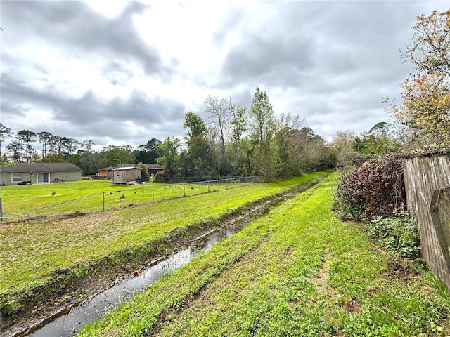 view of yard featuring a rural view and fence