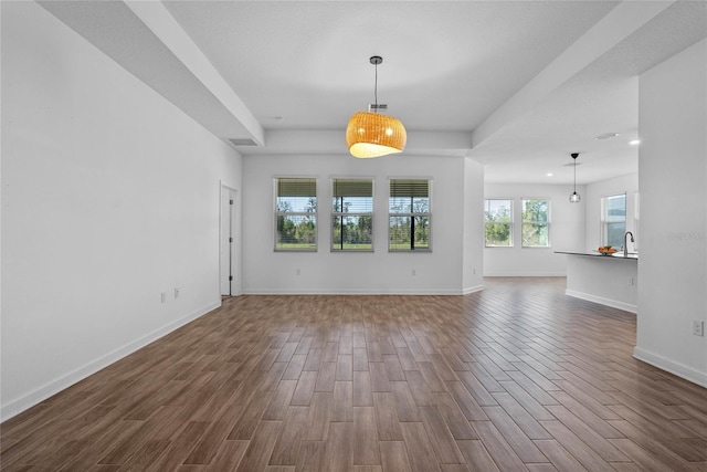 unfurnished living room featuring a sink, baseboards, dark wood finished floors, and recessed lighting