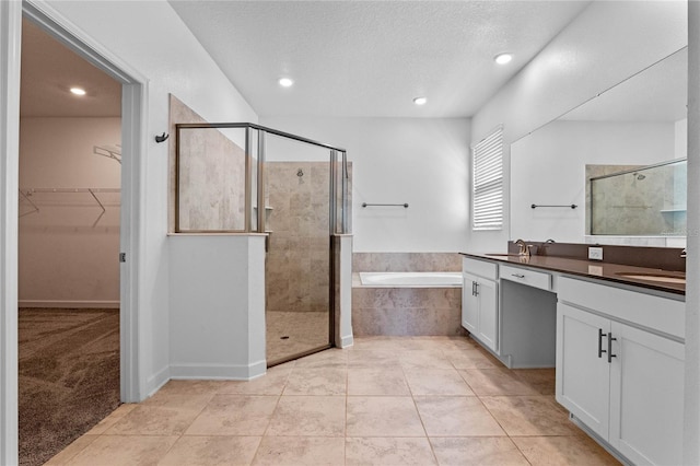 bathroom with a bath, a stall shower, and a sink