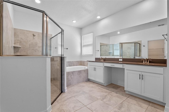 bathroom with visible vents, a garden tub, double vanity, a stall shower, and a sink