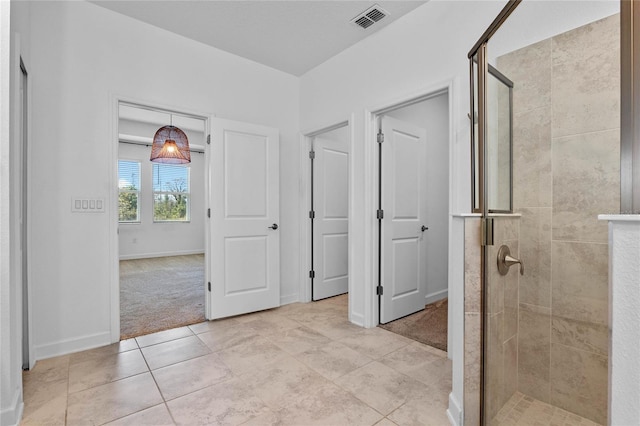 interior space with light tile patterned floors, baseboards, visible vents, and light carpet