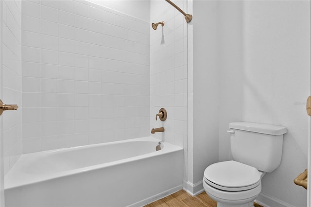 bathroom with  shower combination, toilet, wood finished floors, and baseboards