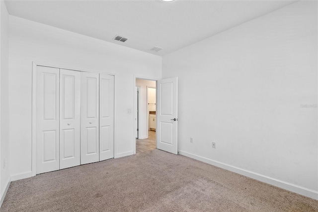 unfurnished bedroom featuring a closet, baseboards, visible vents, and carpet floors