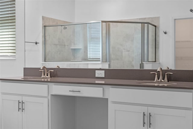 full bath with double vanity, a stall shower, and a sink