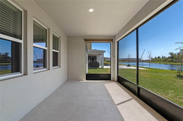 unfurnished sunroom with plenty of natural light and a water view