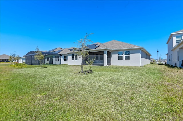 back of property featuring stucco siding, a lawn, solar panels, and glass enclosure