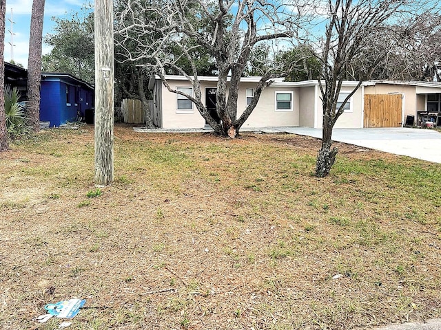 view of front of house featuring a front yard, fence, and stucco siding