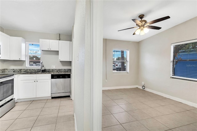 kitchen featuring appliances with stainless steel finishes, a sink, white cabinetry, and a healthy amount of sunlight