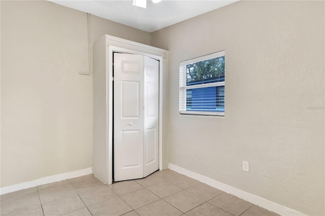 interior space with light tile patterned floors and baseboards