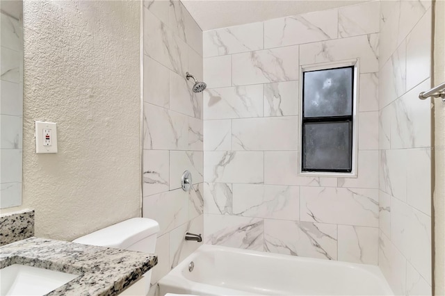 full bath featuring toilet, bathing tub / shower combination, vanity, and a textured wall