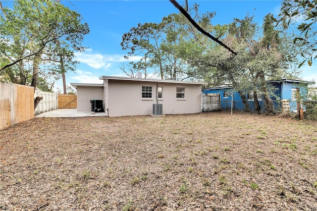 rear view of property featuring a fenced backyard, central AC unit, a lawn, and a patio