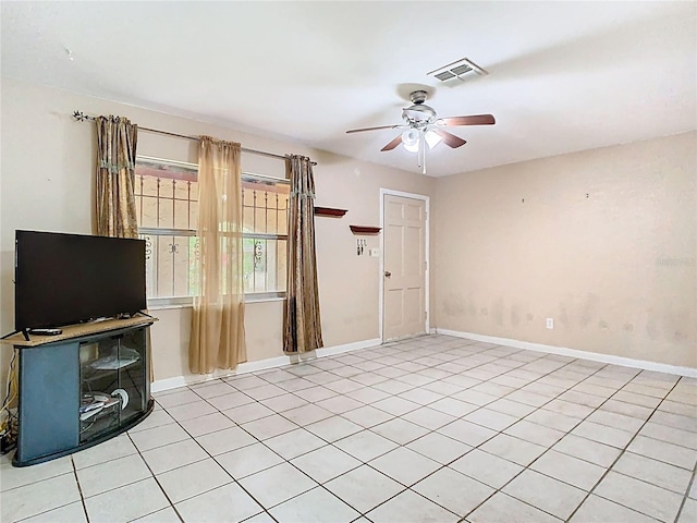 interior space featuring light tile patterned floors, ceiling fan, visible vents, and baseboards