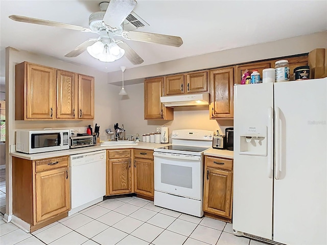 kitchen featuring white appliances, under cabinet range hood, light countertops, and a sink