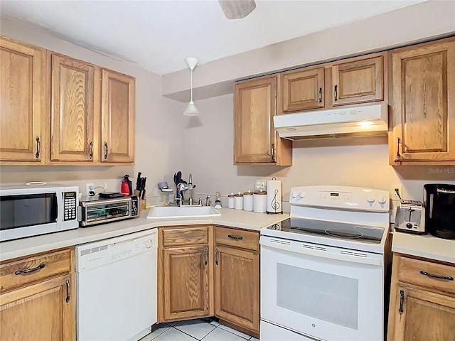 kitchen featuring white appliances, a toaster, light countertops, under cabinet range hood, and a sink