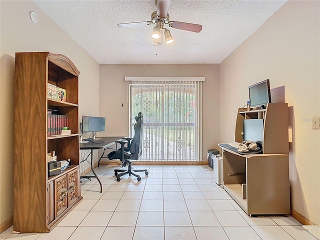 home office featuring a textured ceiling, light tile patterned flooring, a ceiling fan, and baseboards