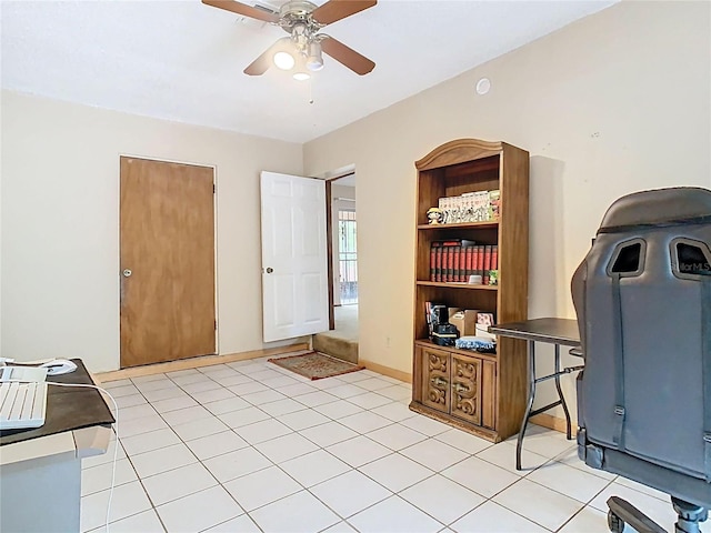 office space featuring ceiling fan, light tile patterned flooring, and baseboards