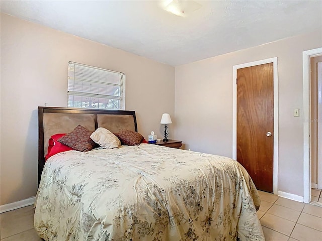 bedroom featuring light tile patterned floors and baseboards