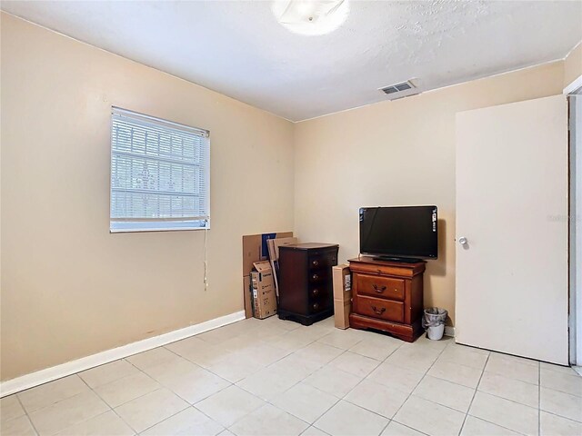 interior space featuring light tile patterned floors, baseboards, and visible vents