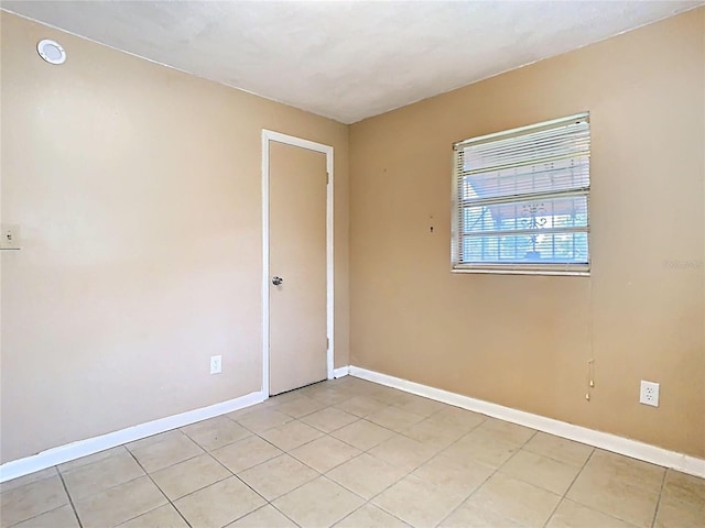 unfurnished room featuring light tile patterned floors and baseboards