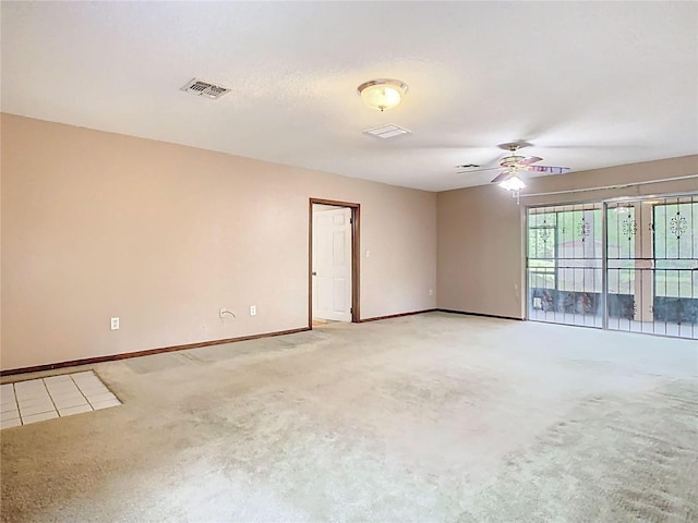 spare room with a ceiling fan, visible vents, and baseboards