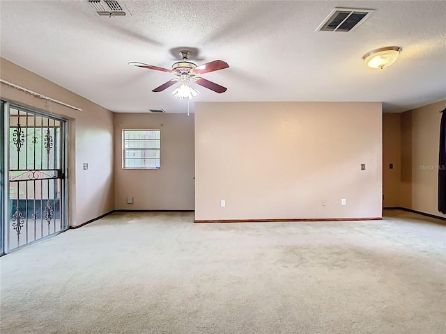 empty room with visible vents, light carpet, and a textured ceiling