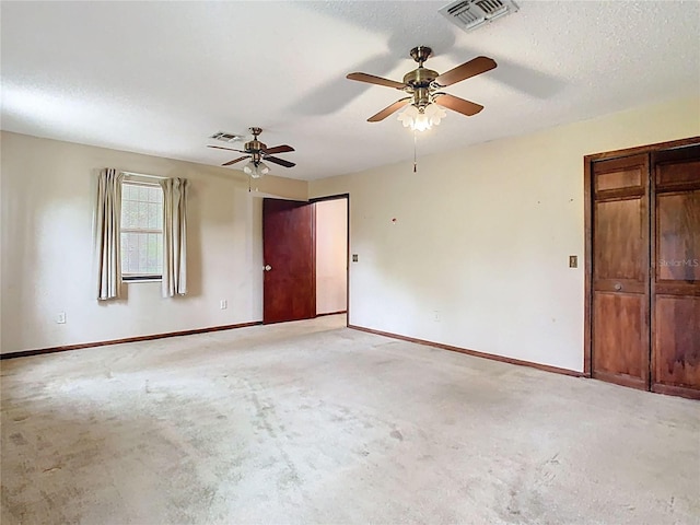 unfurnished room featuring baseboards, visible vents, and a textured ceiling