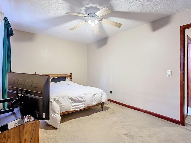 carpeted bedroom featuring a ceiling fan, a textured ceiling, and baseboards