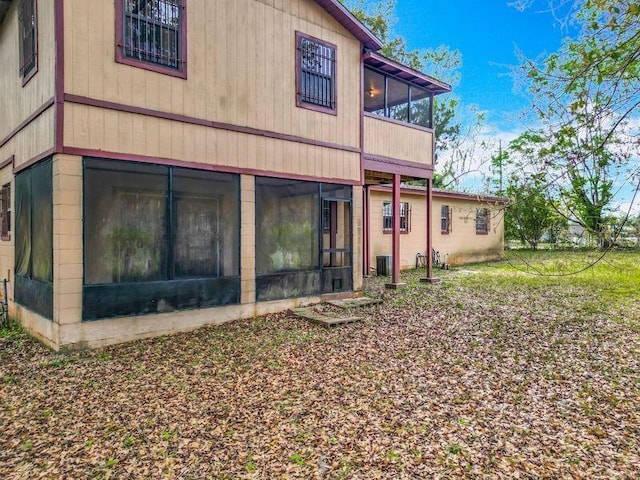 rear view of property featuring a sunroom