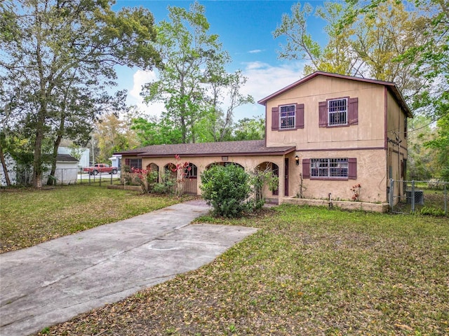 view of front of house featuring concrete driveway, a front yard, and fence