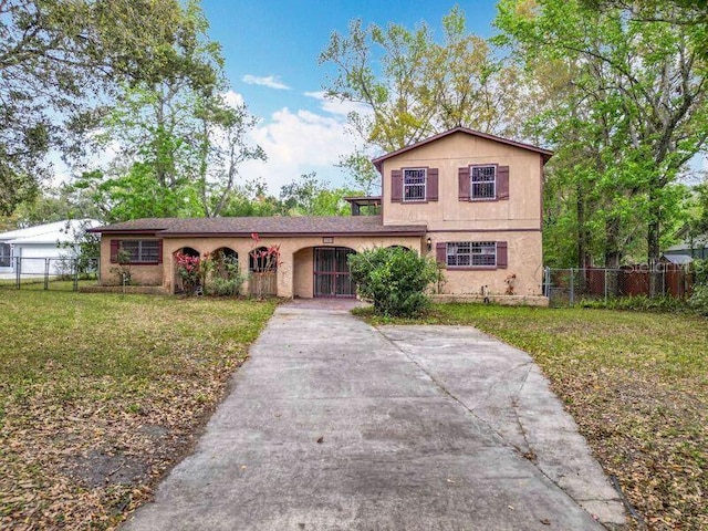 view of front facade featuring a front yard, fence, and driveway