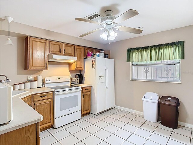 15523 Old Cheney Hwy, Orlando, FL 32828 - kitchen with white appliances, under cabinet range hood, light countertops, a sink, and brown cabinetry