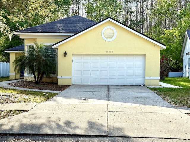 view of front of property with a garage, roof with shingles, and stucco siding