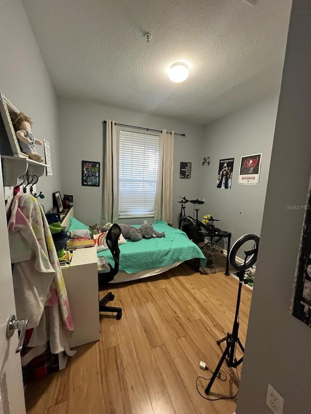 bedroom featuring a textured ceiling and wood finished floors