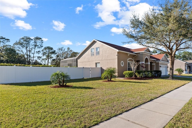 view of property exterior with a garage, a yard, fence private yard, and stucco siding