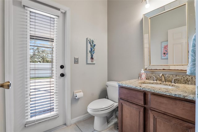 half bath featuring tile patterned flooring, plenty of natural light, vanity, and toilet