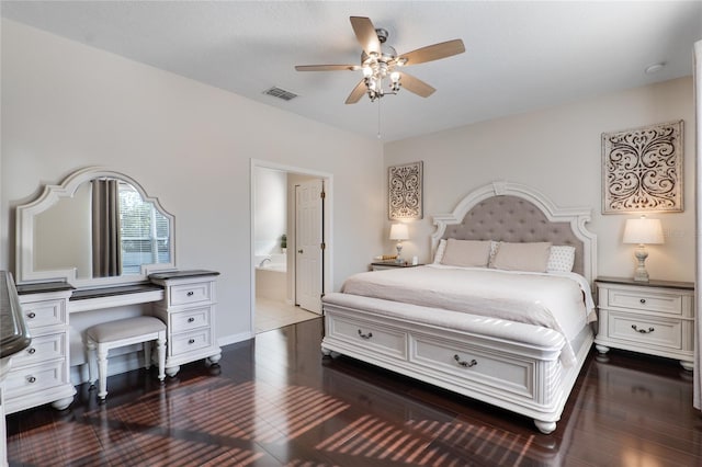 bedroom featuring dark wood-style floors, a ceiling fan, visible vents, and ensuite bathroom