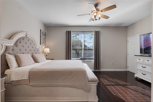 bedroom featuring dark wood-style floors, a textured ceiling, a ceiling fan, and baseboards