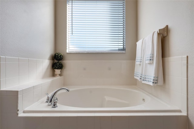 bathroom with a bath and a textured wall