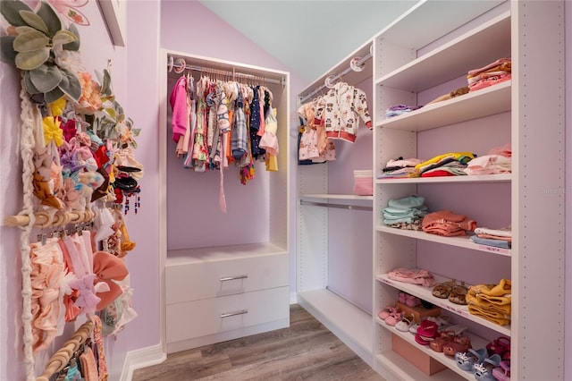 spacious closet with vaulted ceiling and wood finished floors