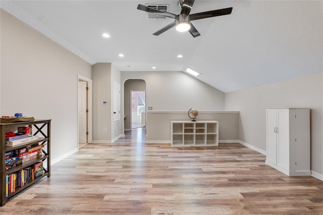 additional living space featuring arched walkways, lofted ceiling, recessed lighting, light wood-style floors, and baseboards