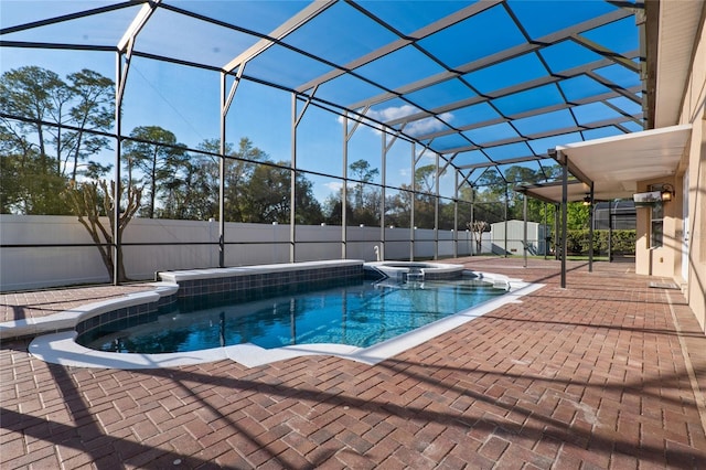 view of swimming pool with a pool with connected hot tub, a lanai, a fenced backyard, and a patio