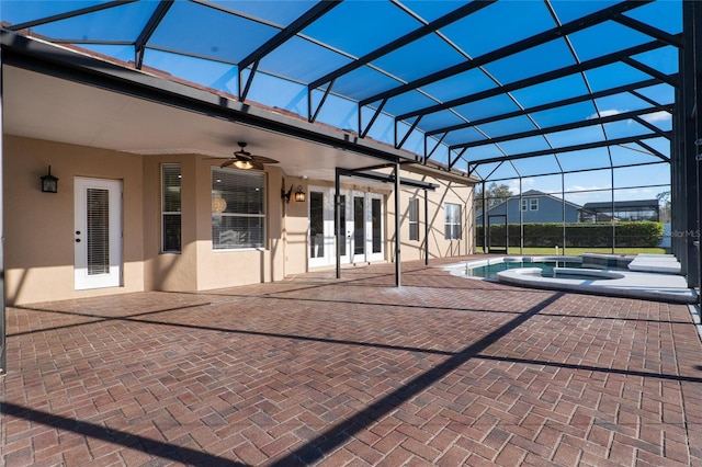 view of patio / terrace with a lanai, ceiling fan, an outdoor pool, and french doors