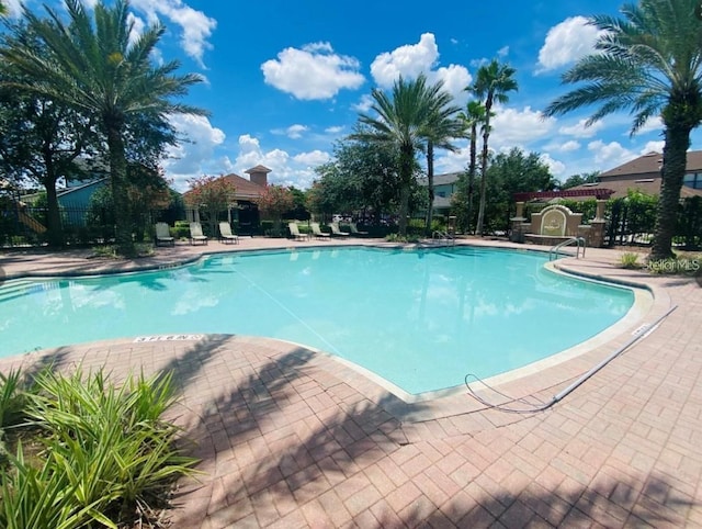 pool with fence and a patio