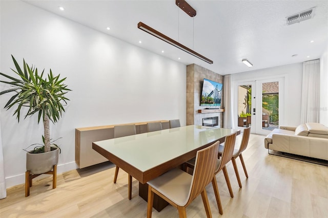 dining space with french doors, light wood finished floors, visible vents, and recessed lighting