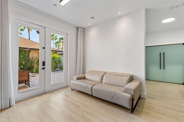 living area featuring light wood finished floors, recessed lighting, and french doors