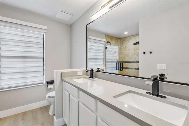 full bath with wood finished floors, a stall shower, a sink, and toilet