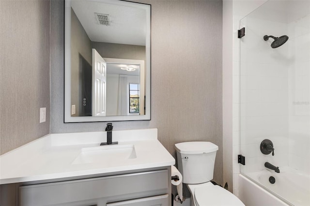 bathroom featuring visible vents, vanity, toilet, and wallpapered walls